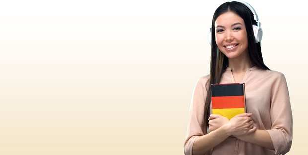 Mädchen, das Deutschbuch in der Hand hält und Kopfhörer trägt
