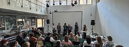 Das Publikum der Abschlussveranstaltung und Personen auf der Bühne