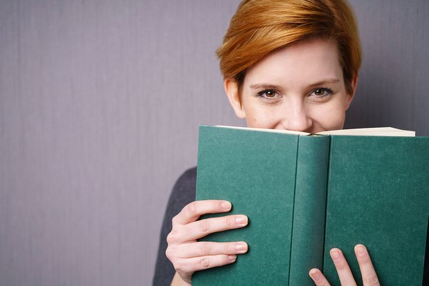 Frau hält grünes Buch